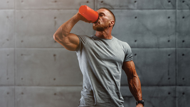homem no ginásio a beber batido de proteína